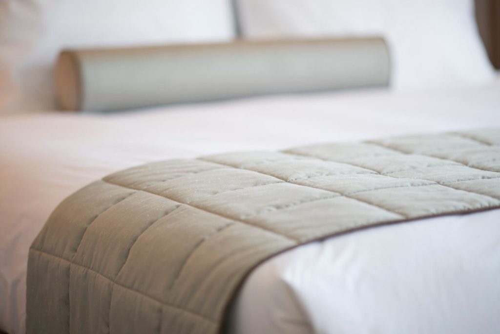 White bedsheet with a quilt